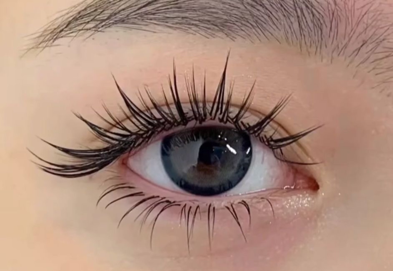 Detailed view of glossy separated lash spikes in the iconic wispy style